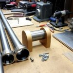 Materiały i narzędzia potrzebne do budowy śrutownika do zboża rozłożone na stole warsztatowym